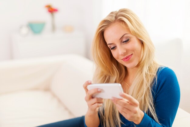 Beautiful woman with white mobile phone at living room