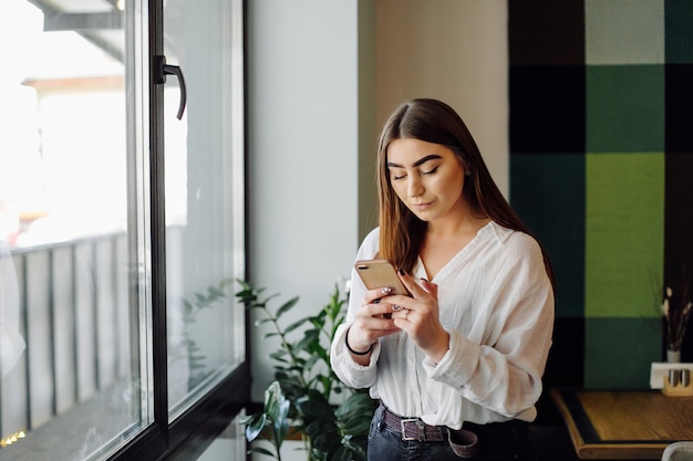 Beautiful woman working on her laptop and phone on a stylish urban restaurant