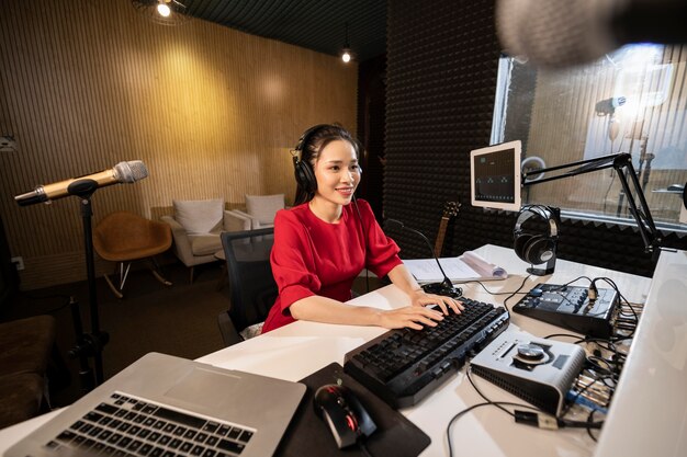 Beautiful woman working at radio with professional equipment