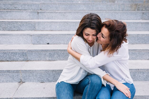 Beautiful women embracing on stairs