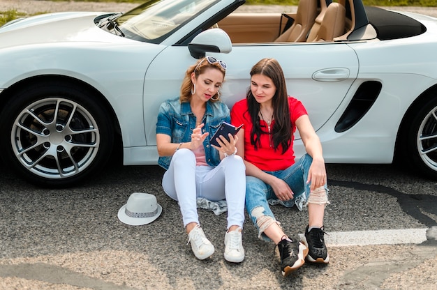 Beautiful women leaning on car