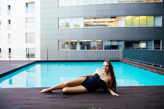 Beautiful women relaxing at the luxury poolside. Girl at travel spa resort pool. Summer luxury vacation.