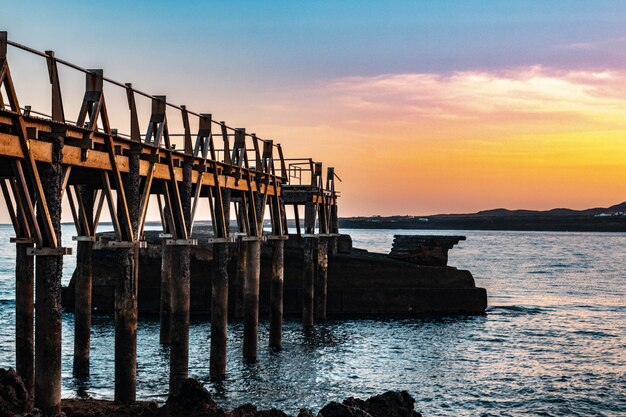 Beautiful wooden pier at the coast of the sea with a beautiful sunset