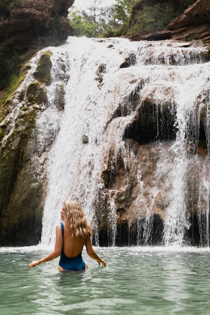 Free photo beautiful young adult by the waterfall