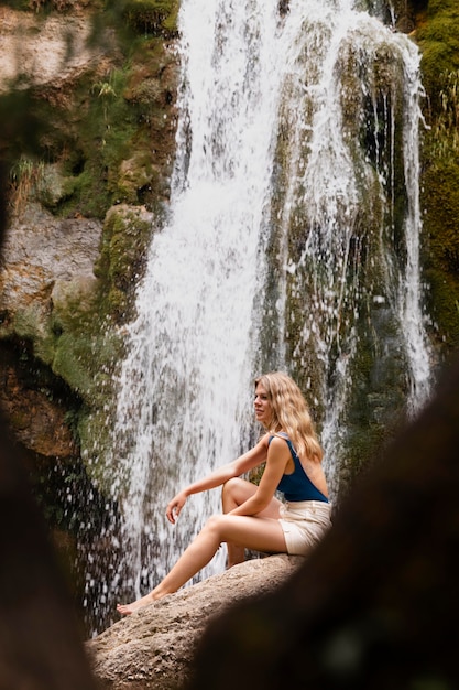 Free photo beautiful young adult by the waterfall