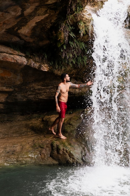 Beautiful young adult by the waterfall