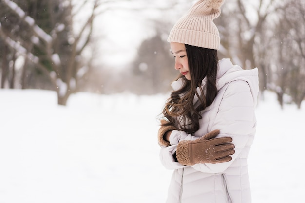 Beautiful young asian woman smiling happy for travel in snow winter season