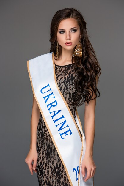 Beautiful young brunette woman with her hair posing in a i long dress.  