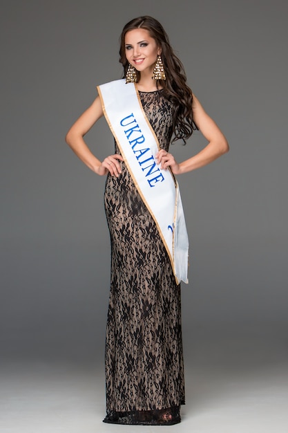 Beautiful young brunette woman with her hair posing in a i long dress.  