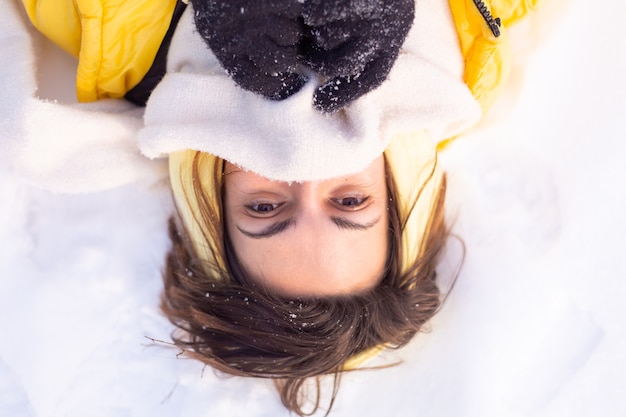 Free photo beautiful young cheerful woman in a snowy landscape winter forest having fun rejoices in winter and snow in warm clothes, scarf