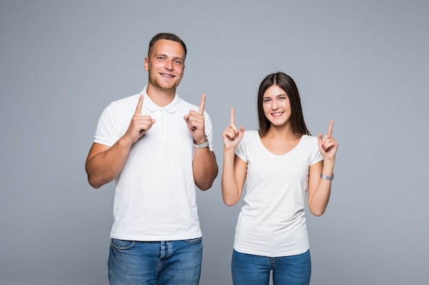 Beautiful young couple in casual clothing white tshirt and jeans holding fingers up