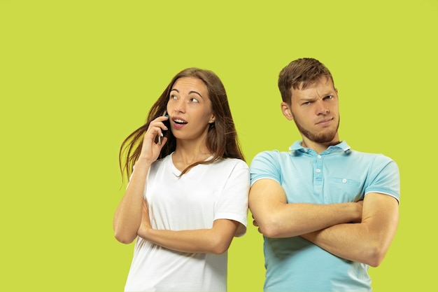 Beautiful young couple's half-length portrait isolated on green