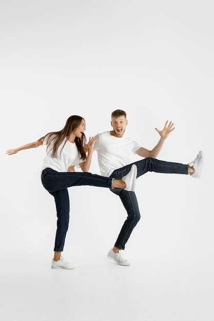 Free Photo beautiful young couple's portrait isolated on white studio background. facial expression, human emotions, advertising concept. copyspace. woman and man jumping, dancing or running together.