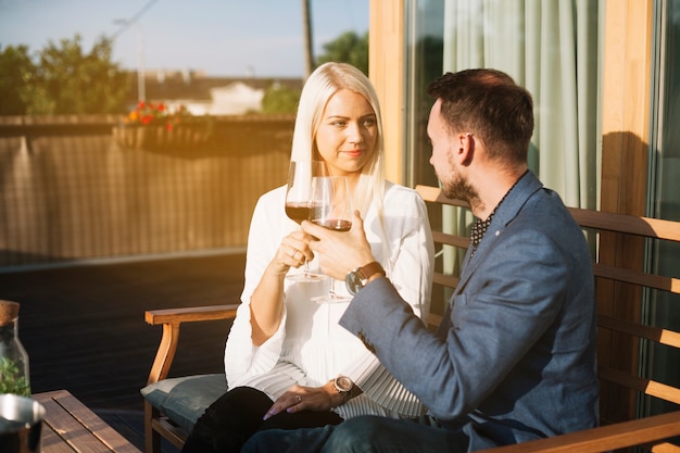 Free Photo beautiful young couple toasting wine glasses