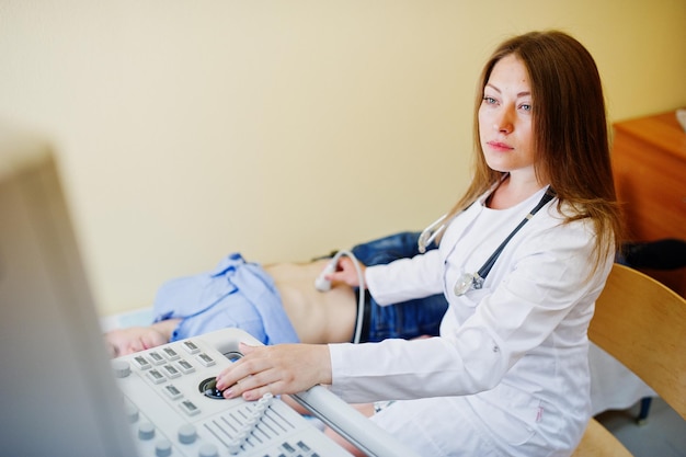 Free photo beautiful young doctor doing diagnostic sonography on a patient