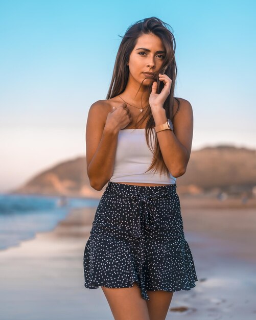 Beautiful young female in casual summer clothing posing while walking in the beach of Zarautz Spain