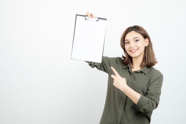 Free Photo beautiful young girl with clipboard standing and posing over white. high quality photo