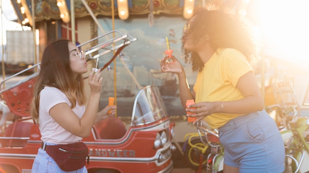 Free photo beautiful young girls having fun at the amusement park