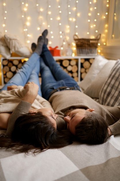 Free photo beautiful young happy couple relaxing in bed and smiling, embracing