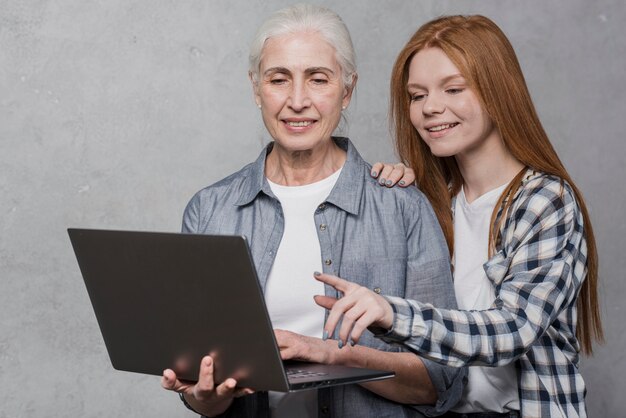 Beautiful young and mature woman looking on a laptop