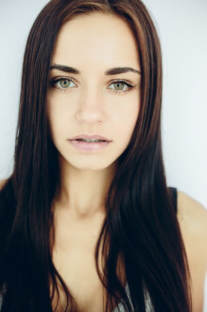 Beautiful young model posing against a white wall