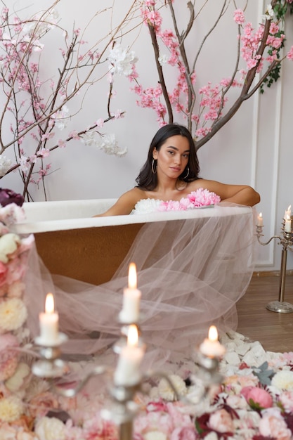 Beautiful young model sittin in a bathtub and looking at the camera High quality photo