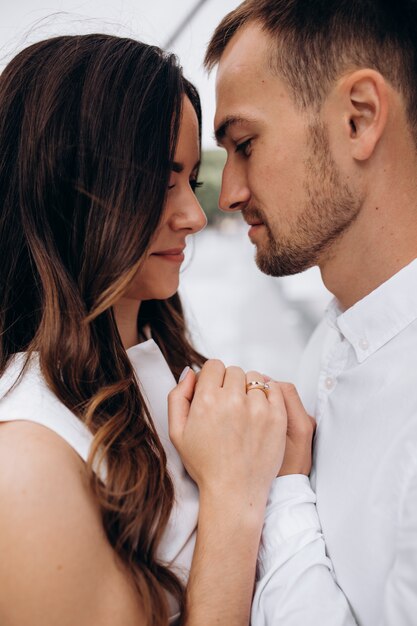 Beautiful young weddign couple kisses and hugs under an umbrella in dark summer day