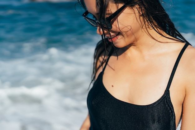 Free photo beautiful young woman in black wet swimsuit