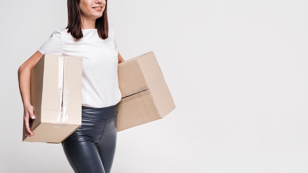 Free photo beautiful young woman carrying cardboard boxes