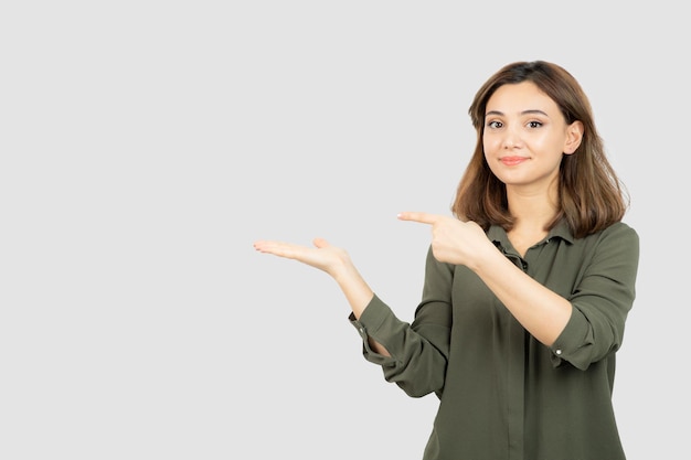 Beautiful young woman in casual outfit showing her opened palms