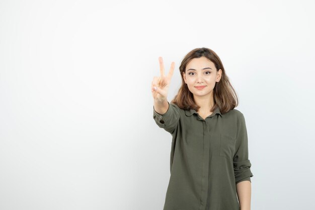 Beautiful young woman in casual outfit standing over white wall. High quality photo