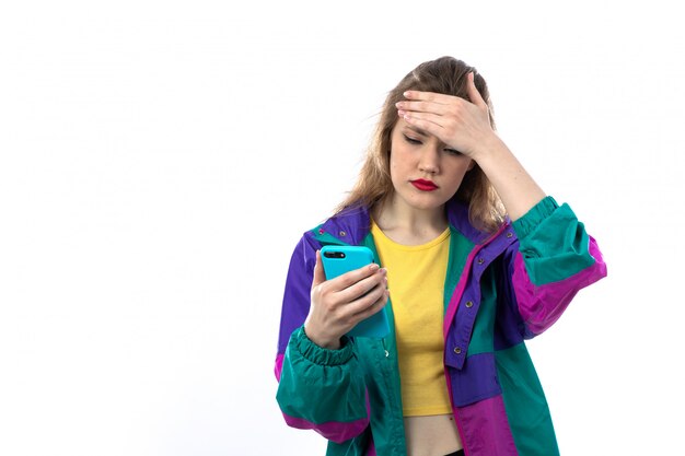 Beautiful young woman in colorful jacket and holding smartphone