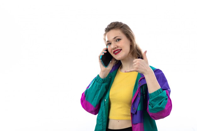 Beautiful young woman in colorful jacket using smartphone