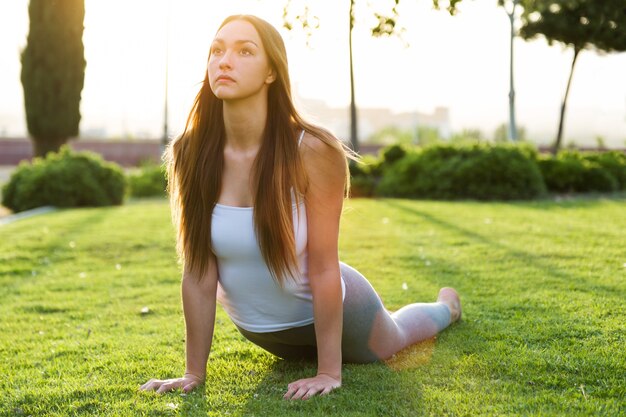 Beautiful young woman doing yoga in the street.