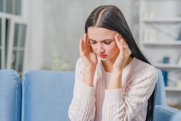 Beautiful young woman having headache