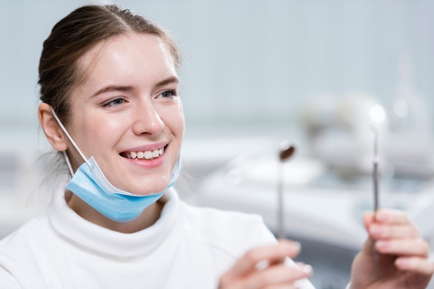 Beautiful young woman holding medical tools