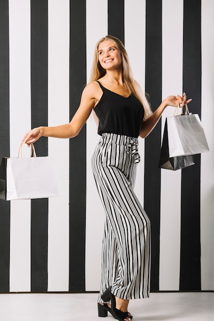 Free Photo beautiful young woman holding shopping bags