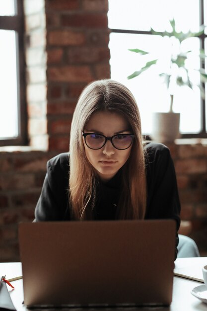 Beautiful young woman in the home office. Working from home. Teleworking concept