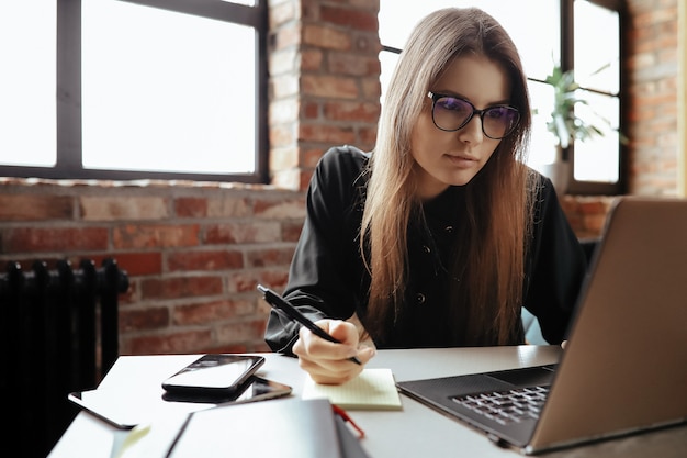 Beautiful young woman in the home office. Working from home. Teleworking concept