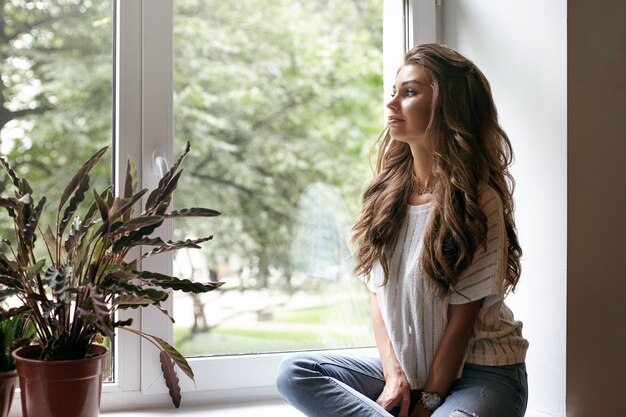 A beautiful young woman is posing in a cafe