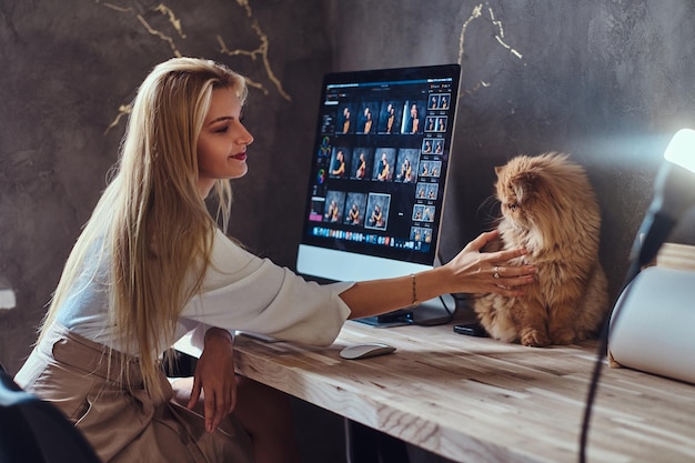 Free Photo beautiful young woman is sitting next to the table while her cat is sitting on the table.