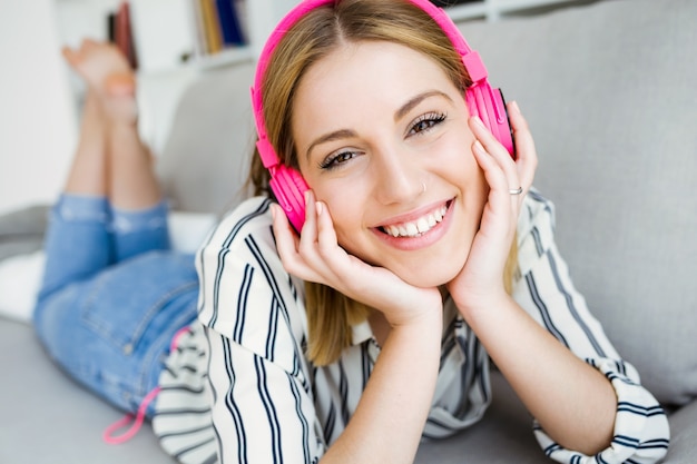 Free Photo beautiful young woman listening to music at home.