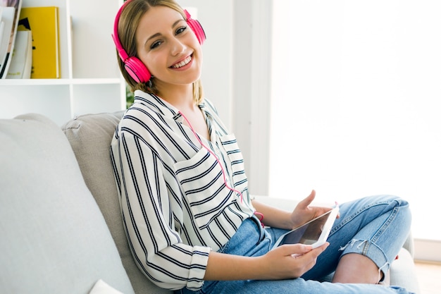 Free Photo beautiful young woman listening to music with digital tablet.