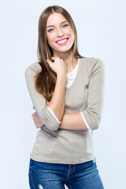 Beautiful young woman looking at camera over white background.