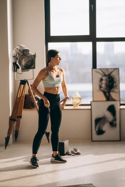 Free photo beautiful young woman performs exercises at home