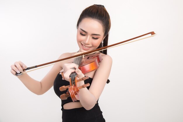 Beautiful young woman playing violin over white background