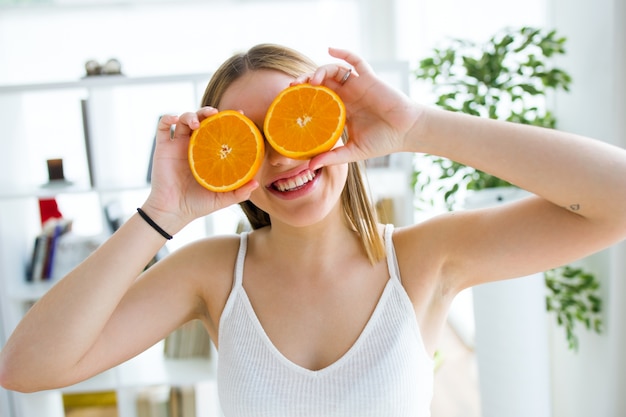 Free Photo beautiful young woman playing with orange fruits.