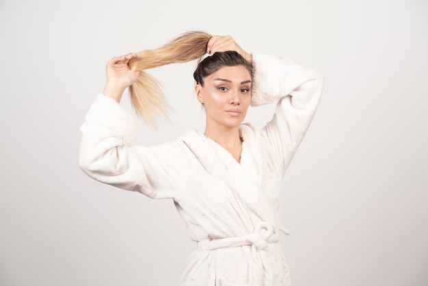 Beautiful young woman posing in a robe