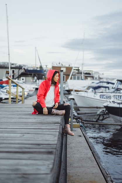 Free Photo beautiful young woman in a red cloak in the yacht port. stockholm, sweden