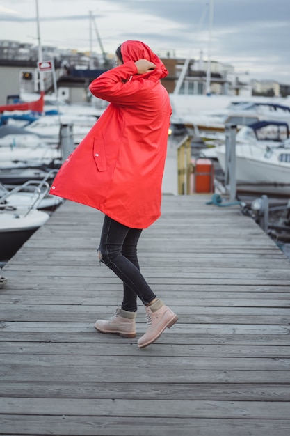 Free Photo beautiful young woman in a red cloak in the yacht port. stockholm, sweden